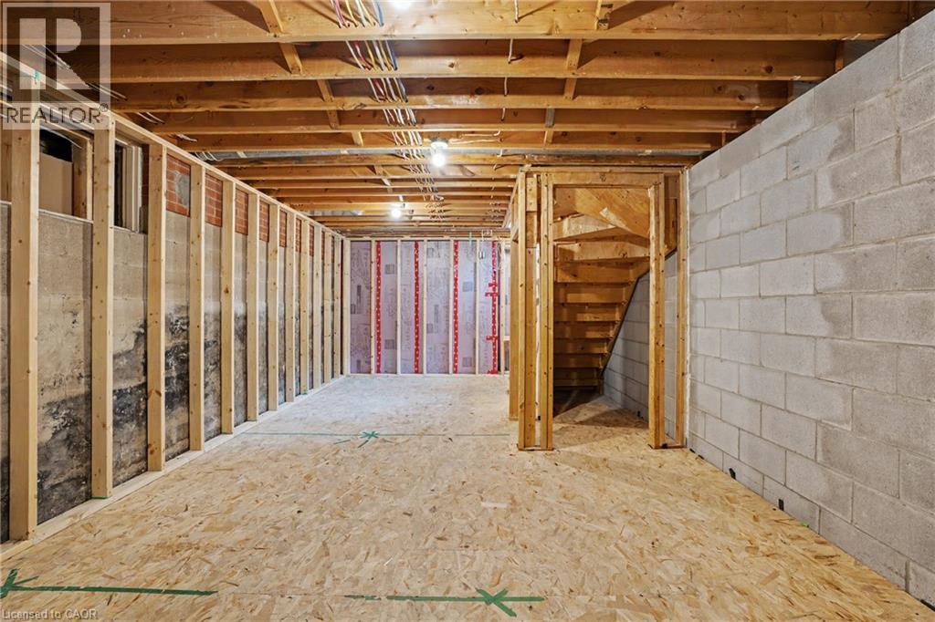 Unfinished basement offering expansive space with wood framing, exposed ceiling joists, electrical conduit, concrete block wall, and subflooring - 100 Hardale Crescent, Hamilton, ON - Indoor Photo Showing Basement