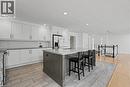 Expansive kitchen featuring a large central island with seating, white shaker cabinetry, stainless steel appliances, and a subway tile backsplash - 100 Hardale Crescent, Hamilton, ON  - Outdoor 