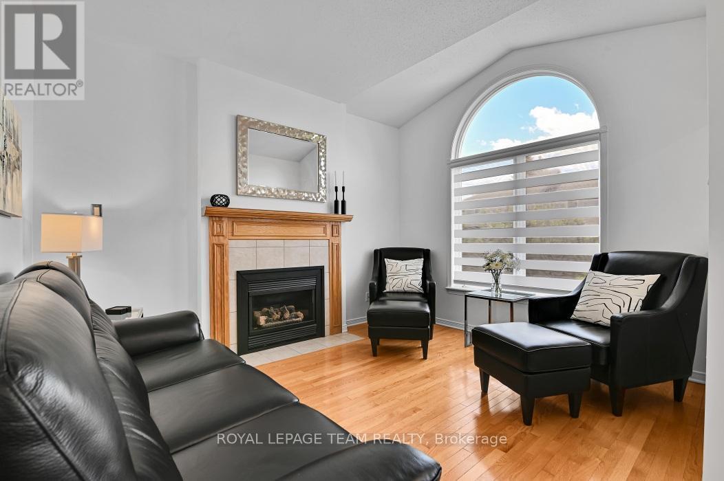 Family room with gas FP and large arched window - 4121 Wolfe Point Way, Ottawa, ON - Indoor Photo Showing Living Room With Fireplace