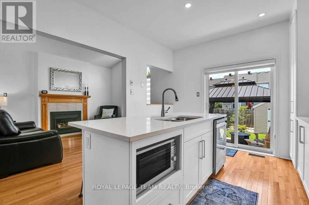 Kitchen with adjacent Family room & access to yard - 4121 Wolfe Point Way, Ottawa, ON - Indoor With Fireplace
