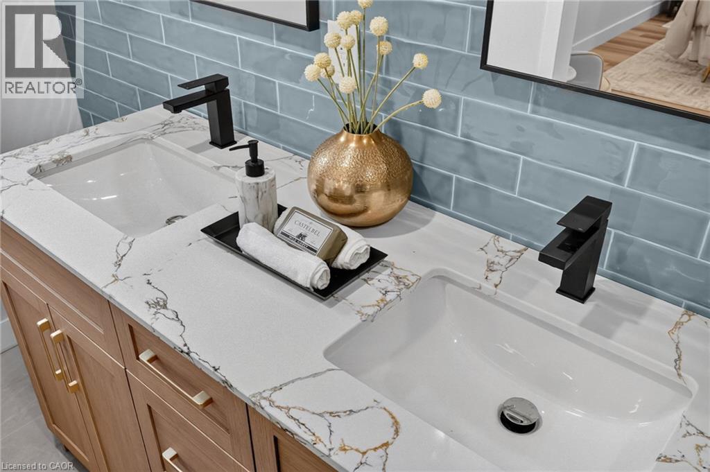 Dual vanity with integrated rectangular sinks and white-veined countertop - 325 Queensdale Avenue E, Hamilton, ON - Indoor Photo Showing Bathroom