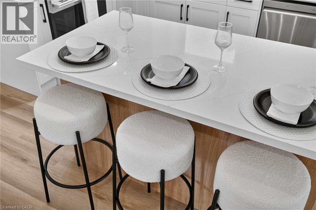 Kitchen island with a white countertop and light wood-finish base - 325 Queensdale Avenue E, Hamilton, ON - Indoor Photo Showing Dining Room