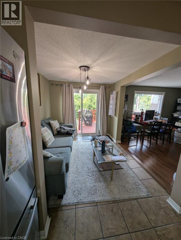 Open-concept living area featuring tile flooring, recessed ceiling lighting, and glass sliding doors opening to an outdoor patio - 466 Bankside Drive, Kitchener, ON - Indoor Photo Showing Other Room