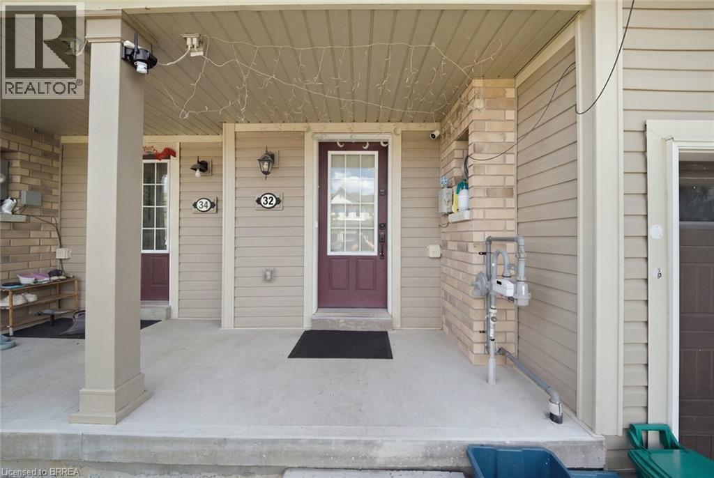 Covered concrete porch with light beige siding and brick accents - 32 Cole Crescent, Brantford, ON - Outdoor With Exterior