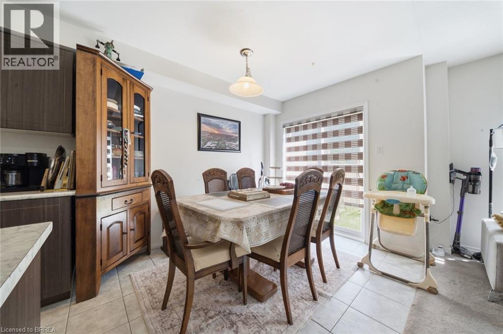 Dining area featuring a sliding glass door with horizontal blinds, overhead lighting, and tile flooring - 32 Cole Crescent, Brantford, ON - Indoor Photo Showing Dining Room