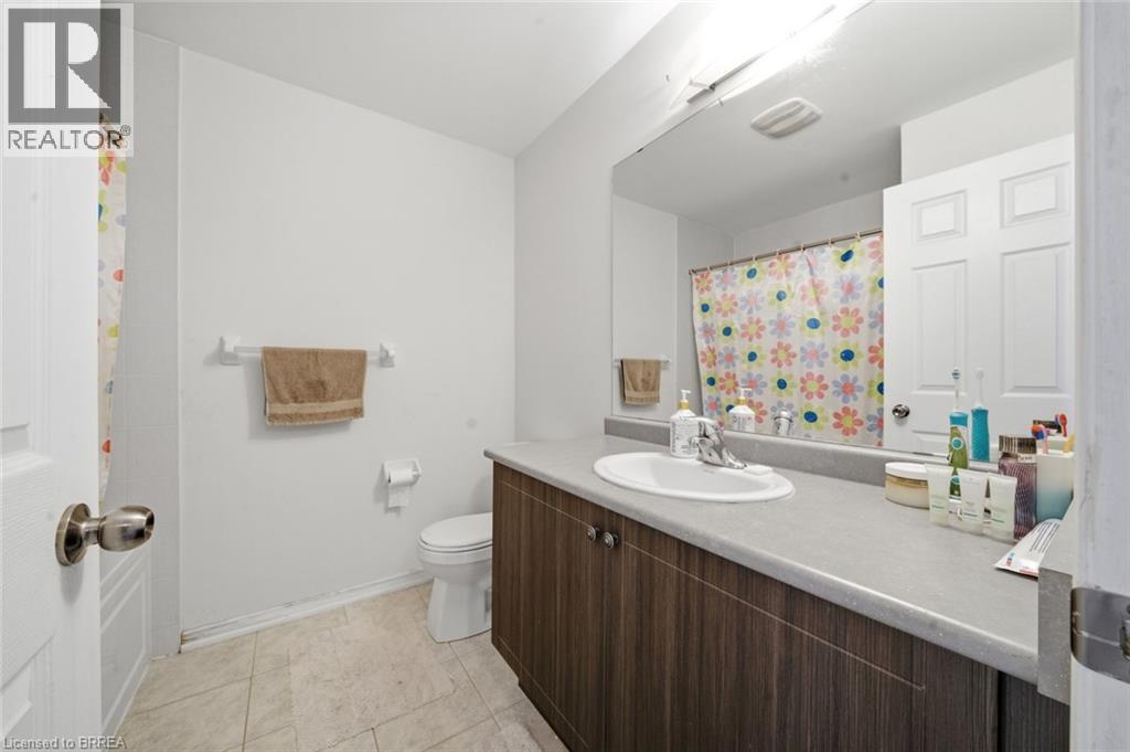 Bathroom featuring a wood-finish vanity with an integrated sink and laminate countertop - 32 Cole Crescent, Brantford, ON - Indoor Photo Showing Bathroom