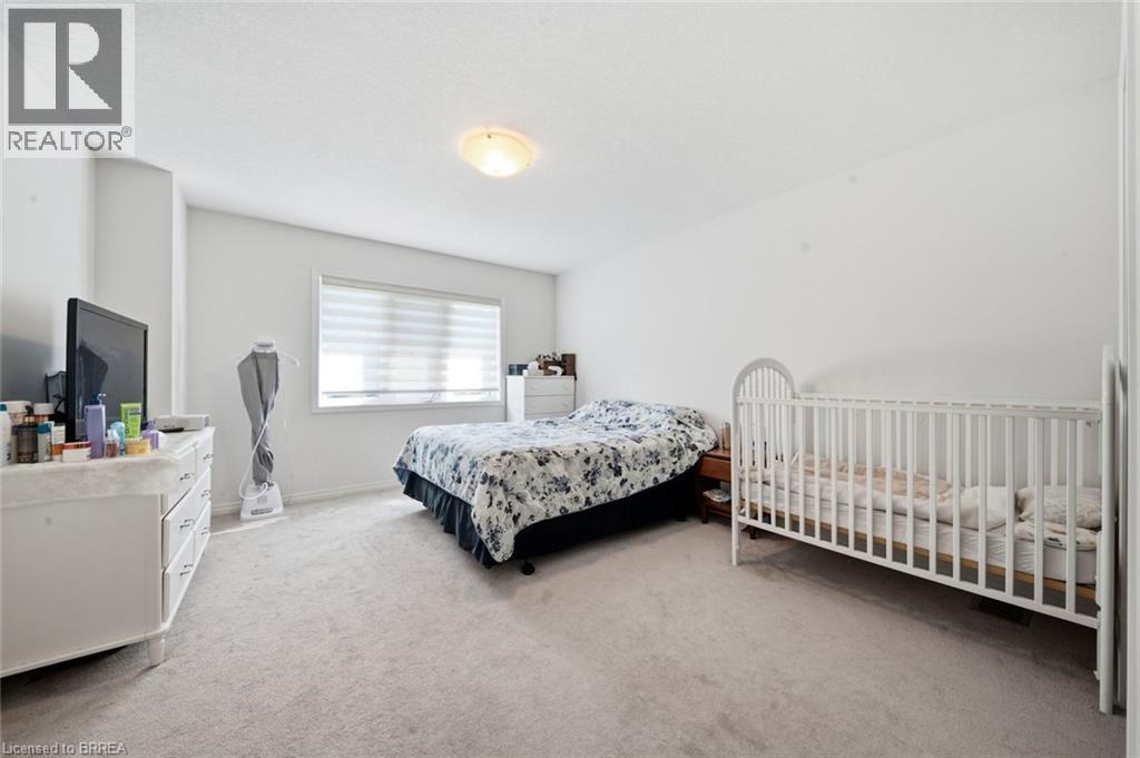 Carpeted bedroom with a window featuring horizontal blinds, recessed ceiling light, and light-toned walls - 32 Cole Crescent, Brantford, ON - Indoor Photo Showing Bedroom