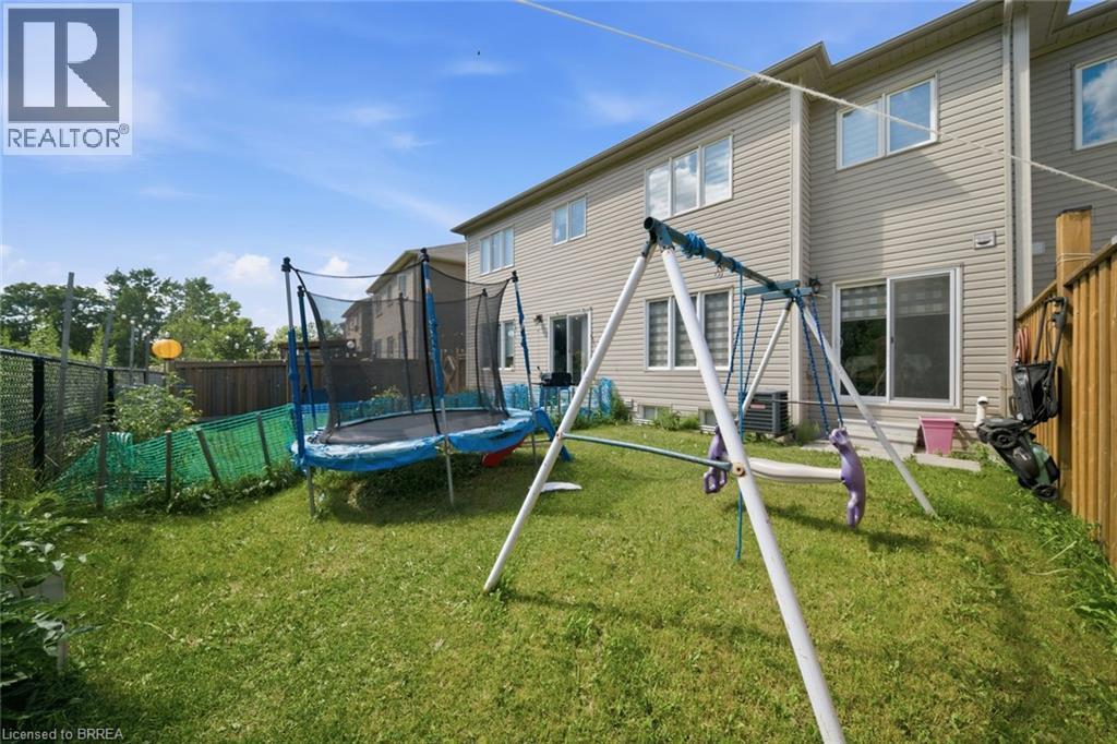 Expansive rear yard featuring green lawn space, a wooden privacy fence, and chain link fencing - 32 Cole Crescent, Brantford, ON - Outdoor