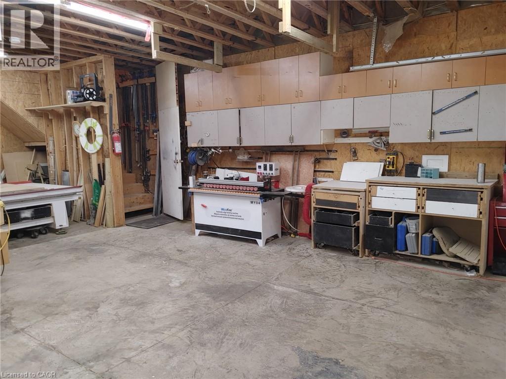 Spacious workshop area featuring exposed ceiling joists and concrete flooring - 76 Brentwood Avenue, Kitchener, ON - Indoor Photo Showing Basement