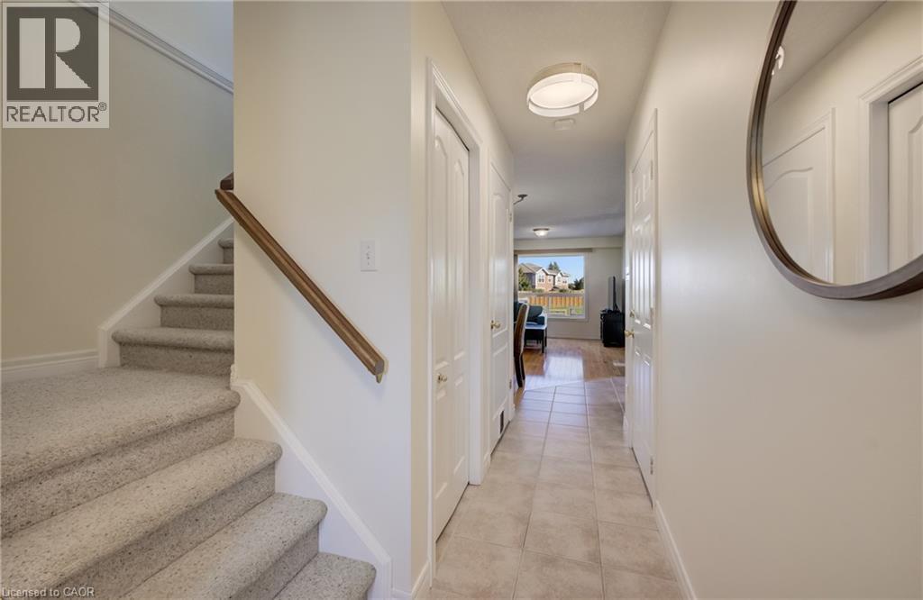 Bright hallway featuring neutral wall finishes, recessed ceiling lighting, and tile flooring that extends toward the main living areas - 496 Langlaw Drive, Cambridge, ON - Indoor Photo Showing Other Room