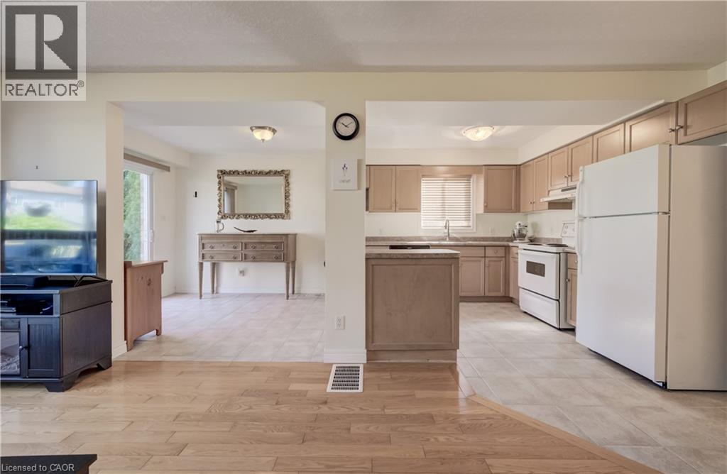 Open-concept kitchen with light-toned cabinetry, white appliances, and a double-basin stainless steel sink - 496 Langlaw Drive, Cambridge, ON - Indoor Photo Showing Kitchen