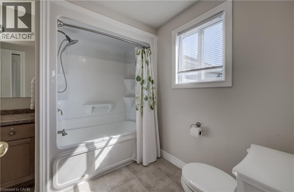 White bathtub and shower combination unit featuring a chrome showerhead and faucet - 496 Langlaw Drive, Cambridge, ON - Indoor Photo Showing Bathroom