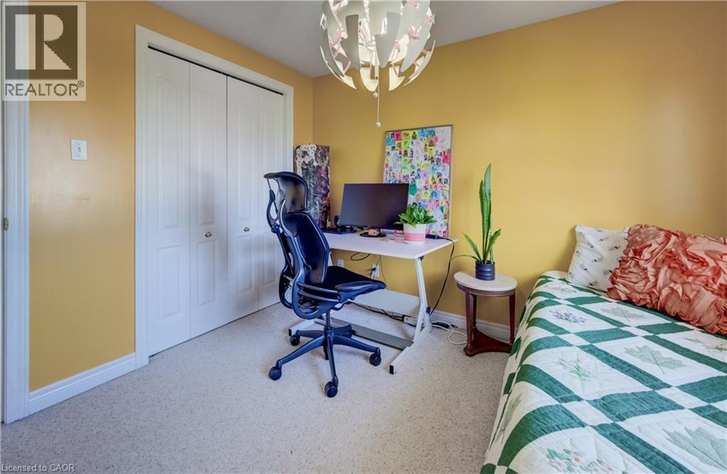 Recessed closet with white bi-fold doors, light-colored carpeting, and a unique overhead light fixture - 496 Langlaw Drive, Cambridge, ON - Indoor Photo Showing Other Room