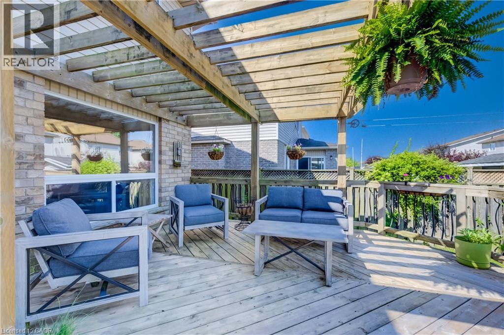 Spacious outdoor deck featuring a wooden pergola, brick exterior, and wood railing - 496 Langlaw Drive, Cambridge, ON - Outdoor With Deck Patio Veranda With Exterior