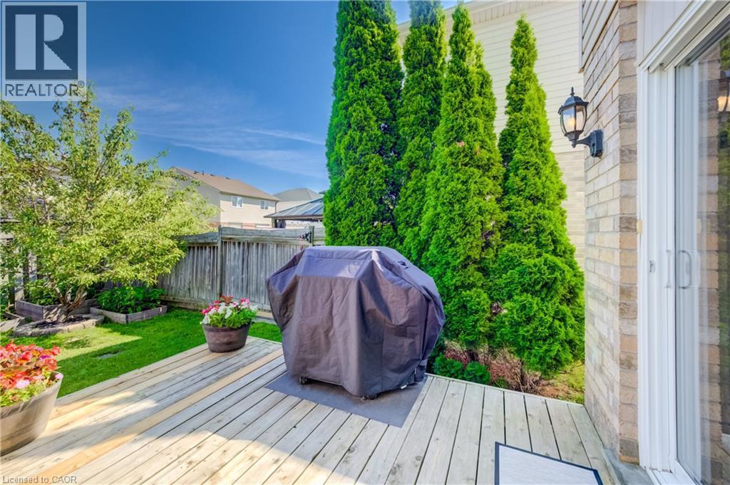 Wood-finish deck with an exterior light fixture, brick siding, and patio door - 496 Langlaw Drive, Cambridge, ON - Outdoor With Deck Patio Veranda