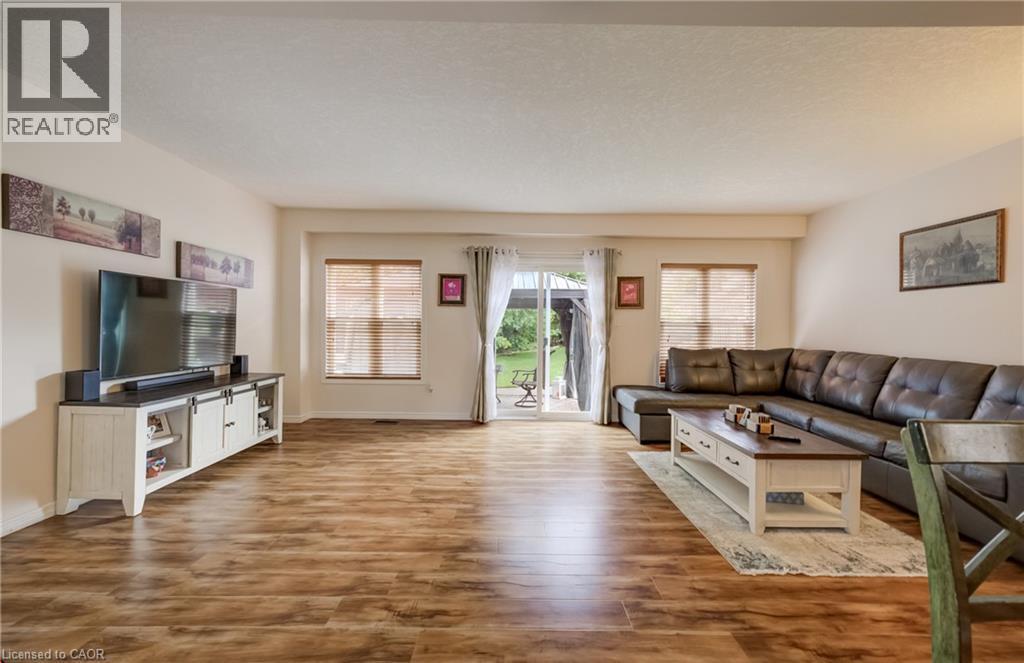 Spacious interior featuring wood-finish flooring, light-toned walls, and a sliding glass door leading to an outdoor area - 521 Snowdrop Court, Kitchener, ON - Indoor Photo Showing Living Room