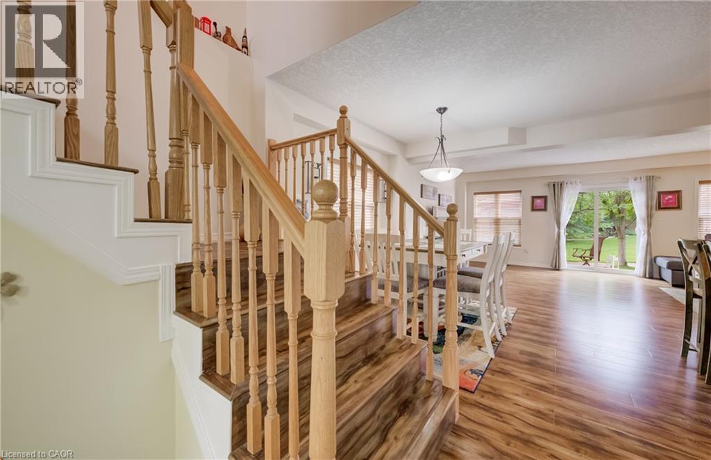 Hardwood staircase with natural wood balusters and railing - 521 Snowdrop Court, Kitchener, ON - Indoor Photo Showing Other Room
