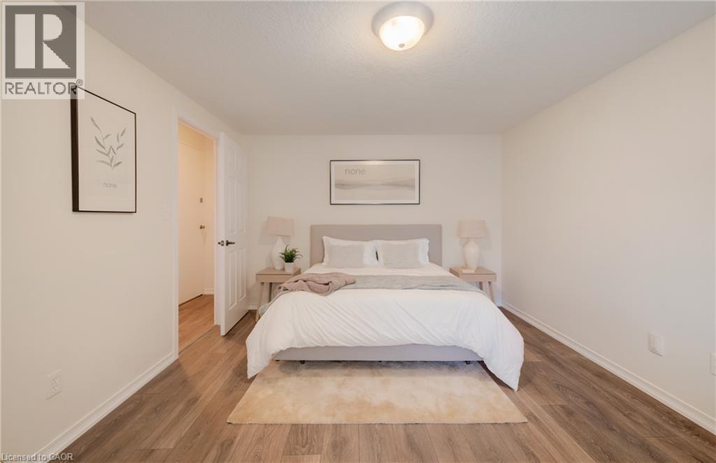 Neutral tone walls complement wood-finish flooring - 521 Snowdrop Court, Kitchener, ON - Indoor Photo Showing Bedroom
