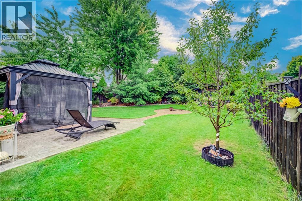 Expansive green lawn with a dark wood fence and mature producing trees. Plum, Cherry, Pear and Apple - 521 Snowdrop Court, Kitchener, ON - Outdoor