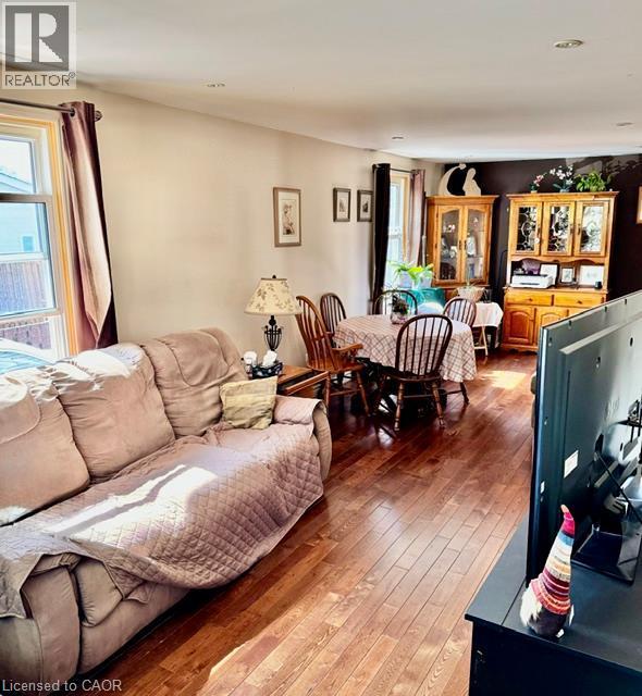 Hardwood-finish flooring throughout, featuring neutral wall tones and ample natural light from multiple windows - 342 Barton Street, Hamilton, ON - Indoor Photo Showing Living Room