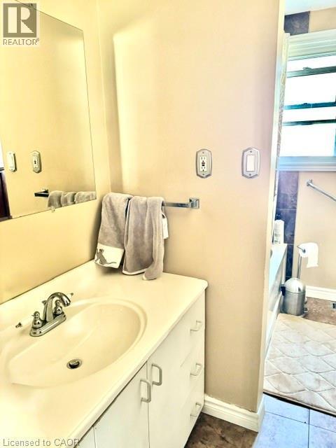 White vanity with an integrated sink and chrome faucet - 342 Barton Street, Hamilton, ON - Indoor Photo Showing Bathroom