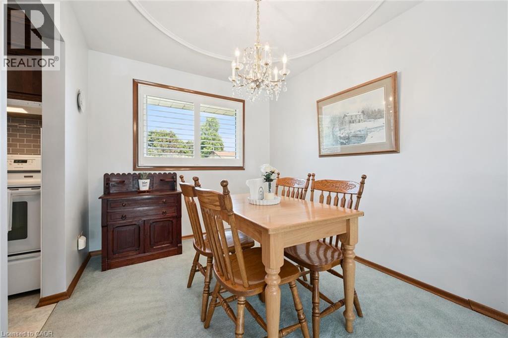 Dining area featuring a crystal chandelier, crown molding, and a window with plantation shutters - 18 Strathcona Crescent, Kitchener, ON - Indoor Photo Showing Dining Room