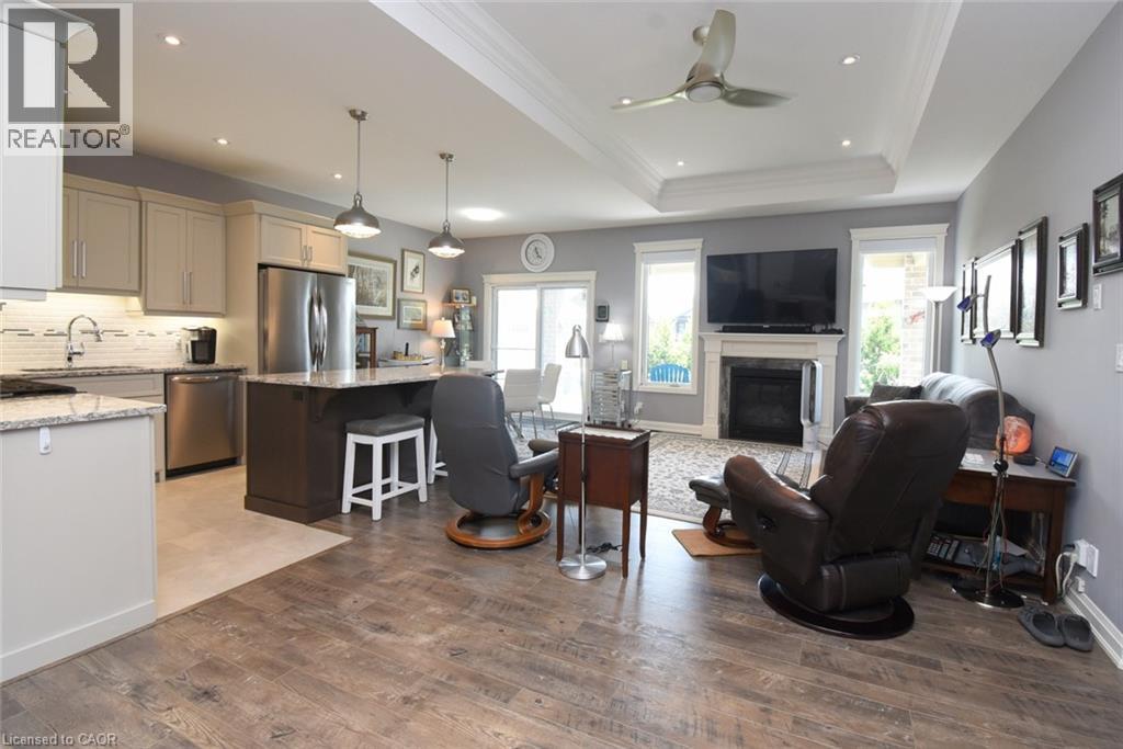 Open-concept living space with wood-finish flooring extending into the living area - 10 Craddock Boulevard, Jarvis, ON - Indoor Photo Showing Kitchen With Fireplace With Upgraded Kitchen