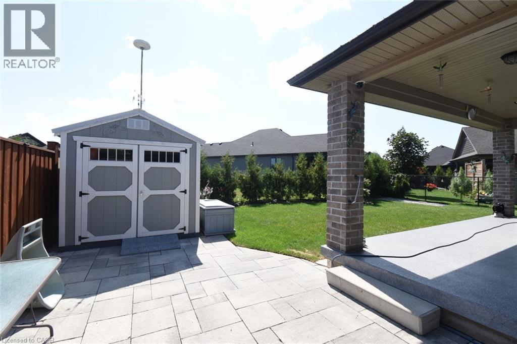 Exterior patio featuring a covered area with brick columns and a separate storage shed - 10 Craddock Boulevard, Jarvis, ON - Outdoor With Deck Patio Veranda
