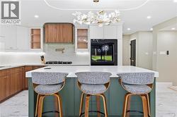 Kitchen island featuring a white countertop, three bar stools, and a green base - 