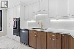 Modern kitchen featuring two-tone cabinetry with white upper cabinets and wood-finish lower cabinets - 