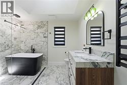 Contemporary bathroom featuring a freestanding black soaking tub, a glass shower enclosure, and full-height marbled wall tiling - 