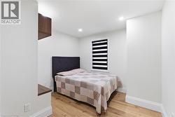 Room featuring light wood-finish flooring, white painted walls, and recessed ceiling lighting - 