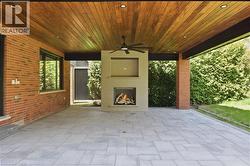 Expansive covered patio featuring a wood-finish plank ceiling with recessed lighting and a ceiling fan - 