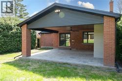 Covered patio featuring brick pillars and a paver stone surface - 