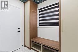 Entryway mudroom with custom wood-finish built-in cabinetry, integrated bench seating, and patterned ceiling accent - 