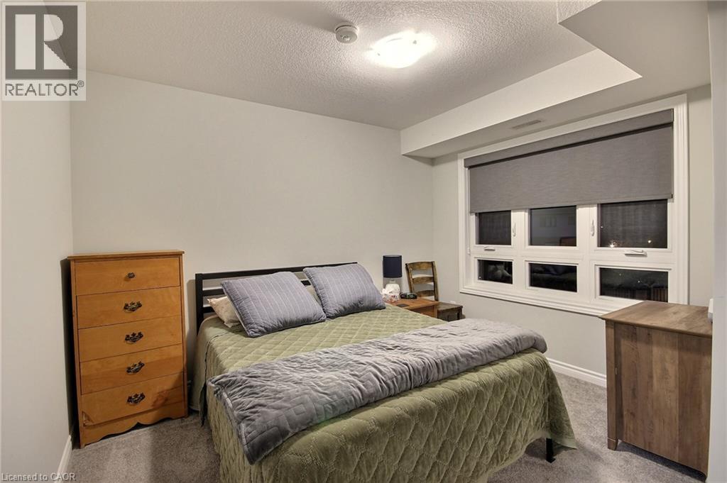 Carpeted room featuring a large window with roller shades, white trim, and a flush-mount ceiling light - 287 Chapel Hill Drive, Kitchener, ON - Indoor Photo Showing Bedroom