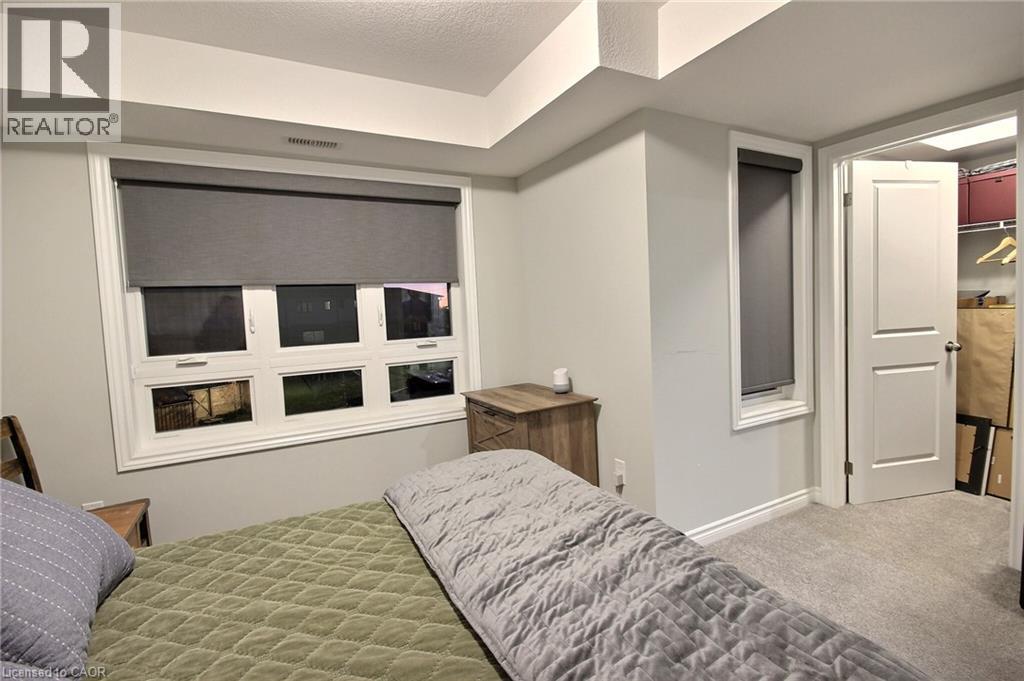 Recessed ceiling with integrated lighting, a large multi-pane window with roller shade, and light gray wall paint - 287 Chapel Hill Drive, Kitchener, ON - Indoor Photo Showing Bedroom