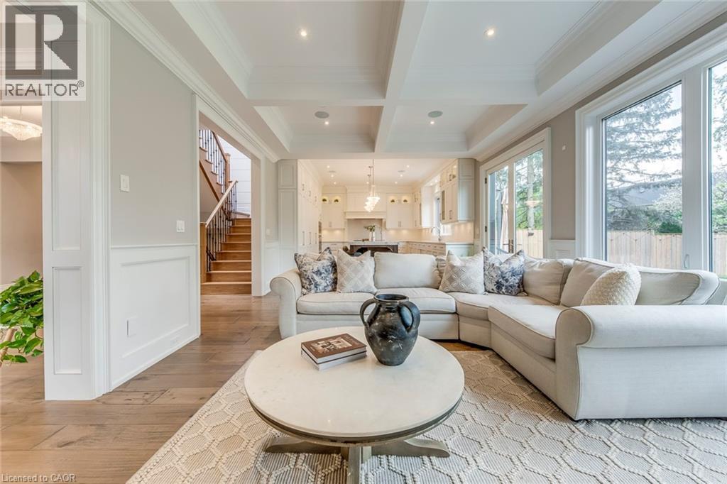 Spacious living area featuring wood-finish flooring, coffered ceilings with recessed lighting, and large windows providing abundant natural light - 436 Willis Drive, Oakville, ON - Indoor Photo Showing Living Room