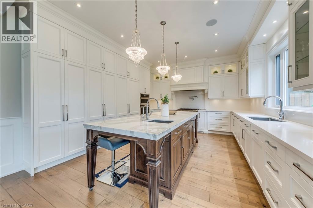 Gourmet kitchen featuring a substantial wood-finish island with a stone countertop, integrated sink, and pendant lighting - 436 Willis Drive, Oakville, ON - Indoor Photo Showing Kitchen With Upgraded Kitchen