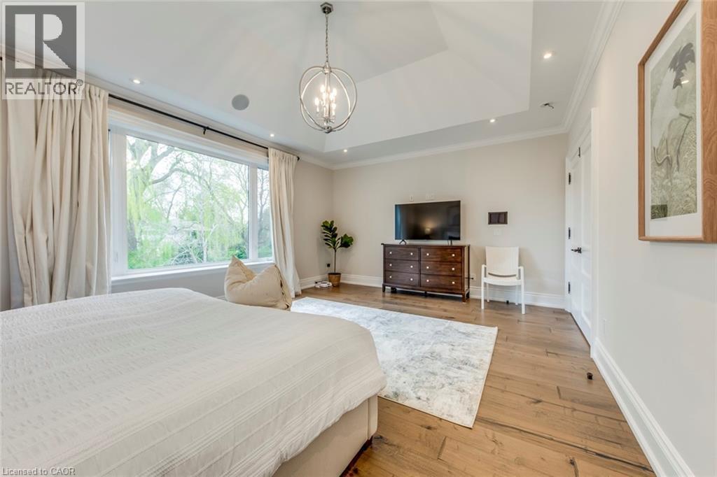 Spacious room featuring a vaulted ceiling, wood-finish flooring, a contemporary chandelier, recessed lighting, and a large window - 436 Willis Drive, Oakville, ON - Indoor Photo Showing Bedroom