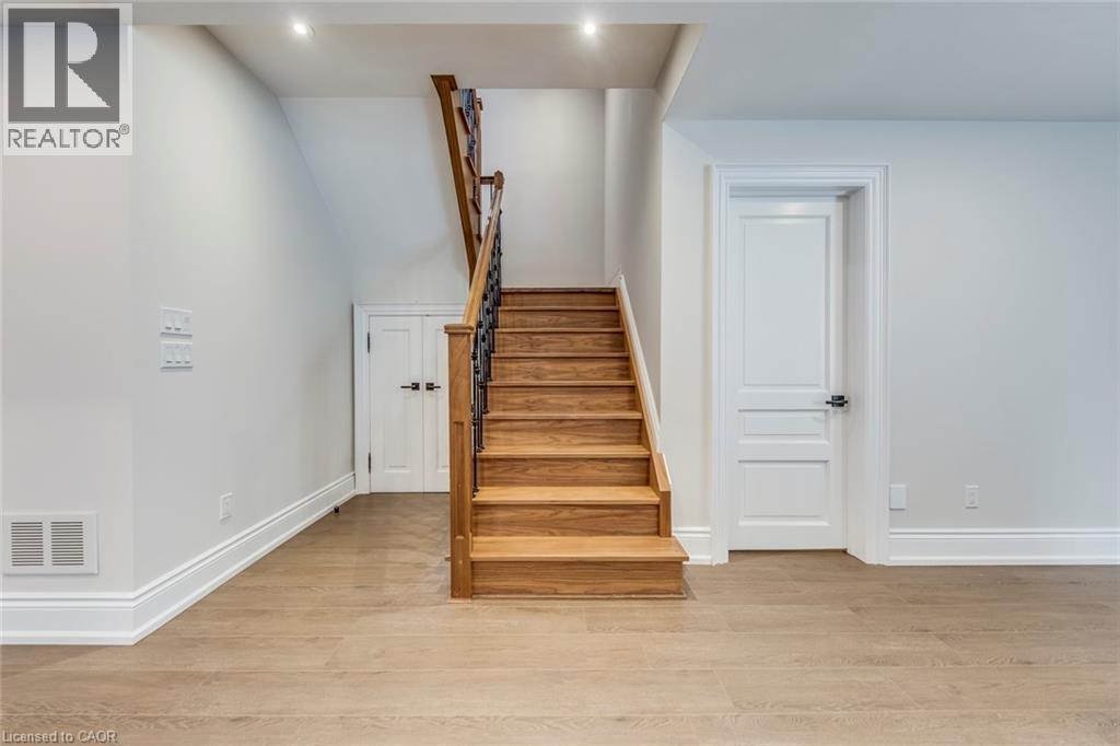 Hardwood staircase with wrought iron balusters - 436 Willis Drive, Oakville, ON - Indoor Photo Showing Other Room