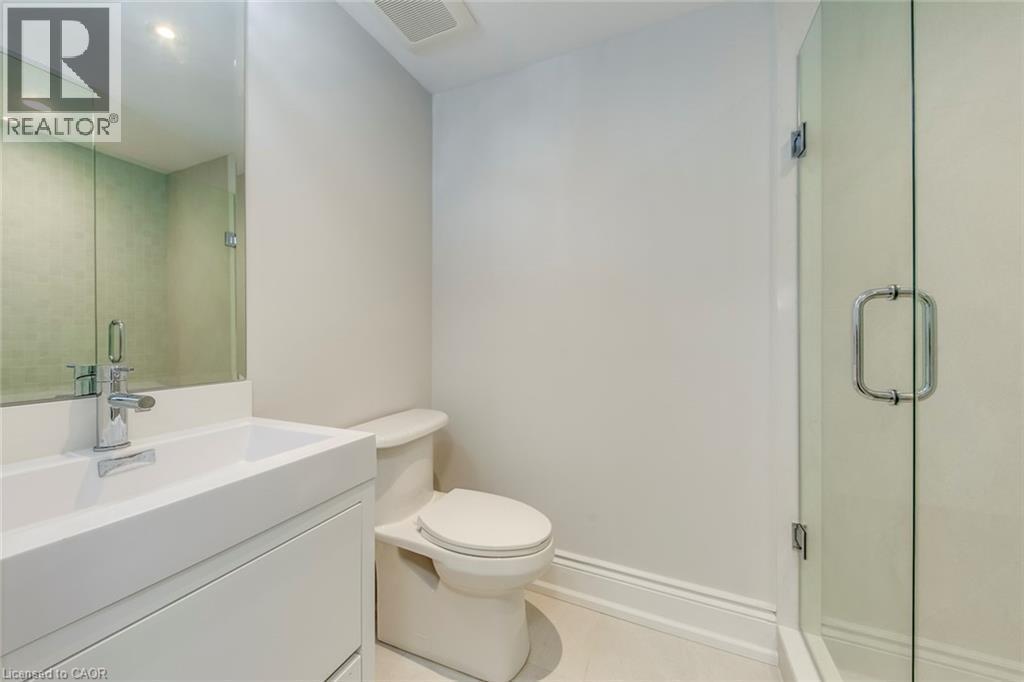 Bathroom featuring a frameless glass shower enclosure, a contemporary white floating vanity with an integrated sink, a chrome single-handle faucet, and an overhead recessed light - 436 Willis Drive, Oakville, ON - Indoor Photo Showing Bathroom