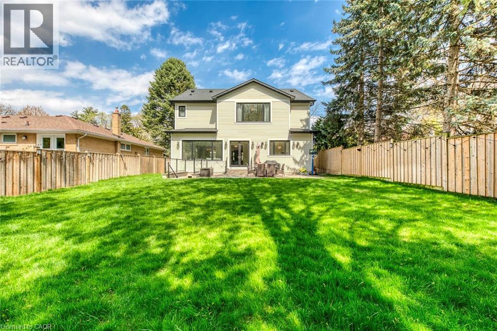 Expansive backyard featuring a lush lawn, privacy fencing, and mature trees - 436 Willis Drive, Oakville, ON - Outdoor
