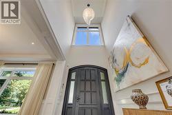 Bright foyer showcasing soaring ceilings with transom window flooding the space with natural light - 