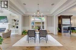 Hardwood flooring, tray ceiling, wainscoting, built-in shelving, and a large window - 