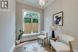 Vaulted ceiling with an elegant chandelier, wood-finish flooring, and a large multi-pane window - 