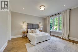 Hardwood flooring, recessed lighting, crown molding, a large window, and a flush mount ceiling light - 