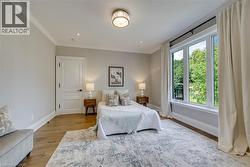 Crown molding, wood-finish flooring, recessed lighting, large pane windows, and a decorative ceiling fixture - 