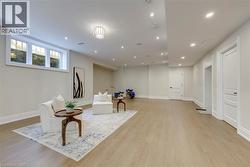 Recessed lighting throughout, wood-finish flooring, white trim, and a window with three panes - 