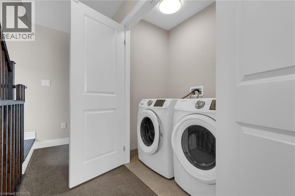 Dedicated laundry area with front-loading appliances, neutral wall paint, and overhead lighting - 2 Waterview Lane, Grimsby, ON - Indoor Photo Showing Laundry Room